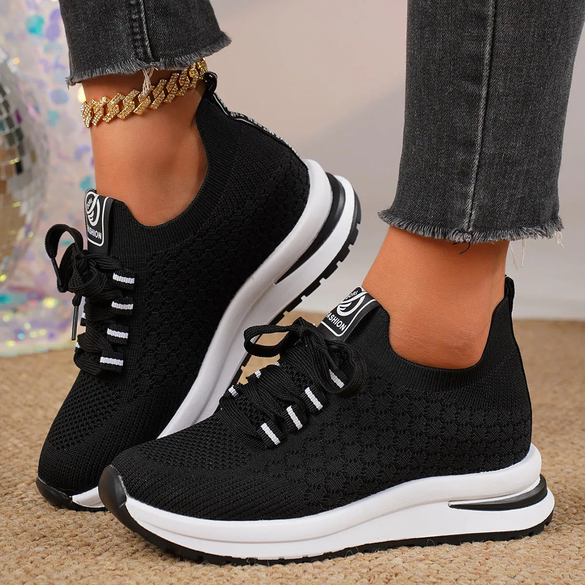 Women's black and white lace-up mesh platform sneakers with a flat rubber sole on a neutral background.