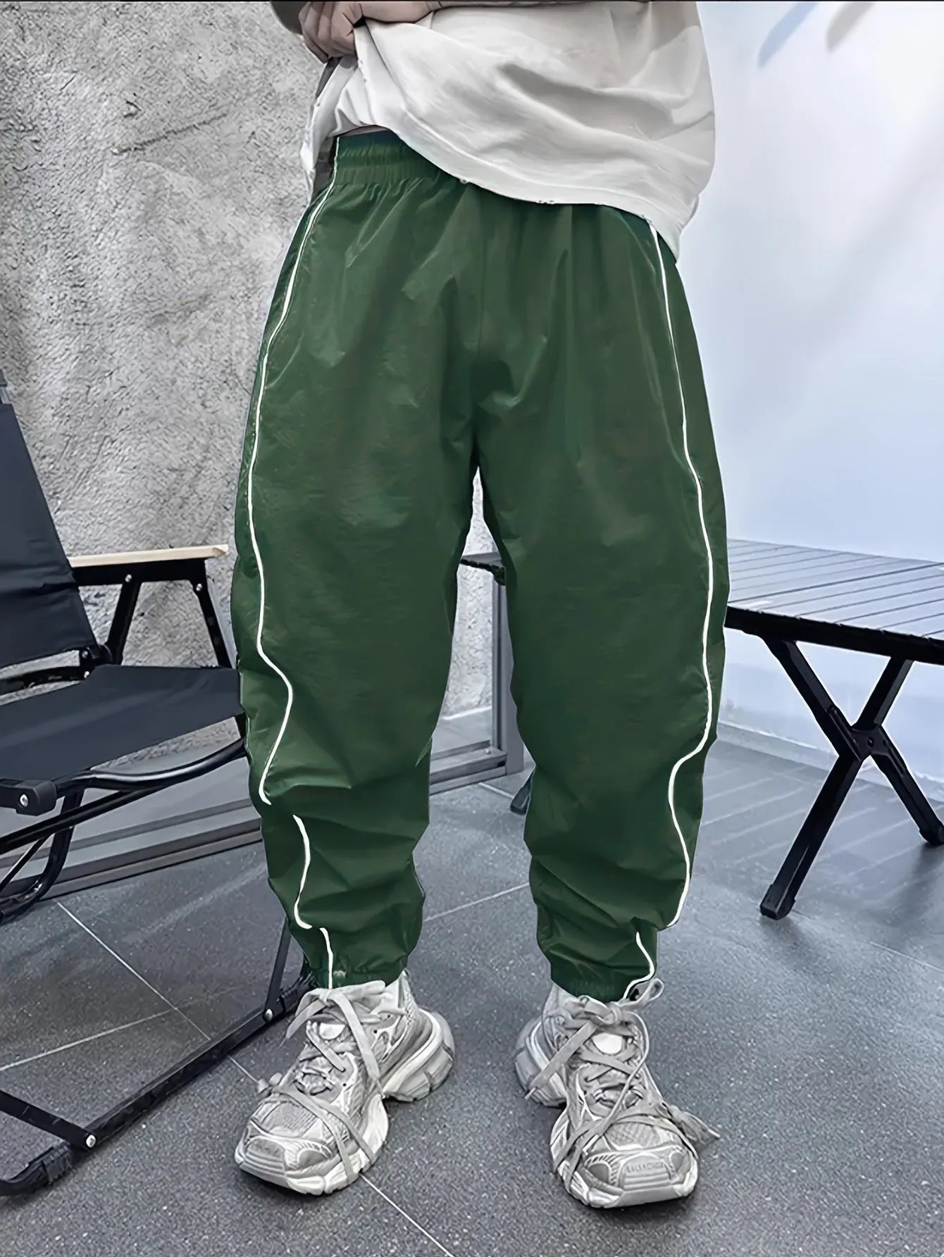 Man wearing loose grey cropped bamboo fibre sports pants in a casual setting.