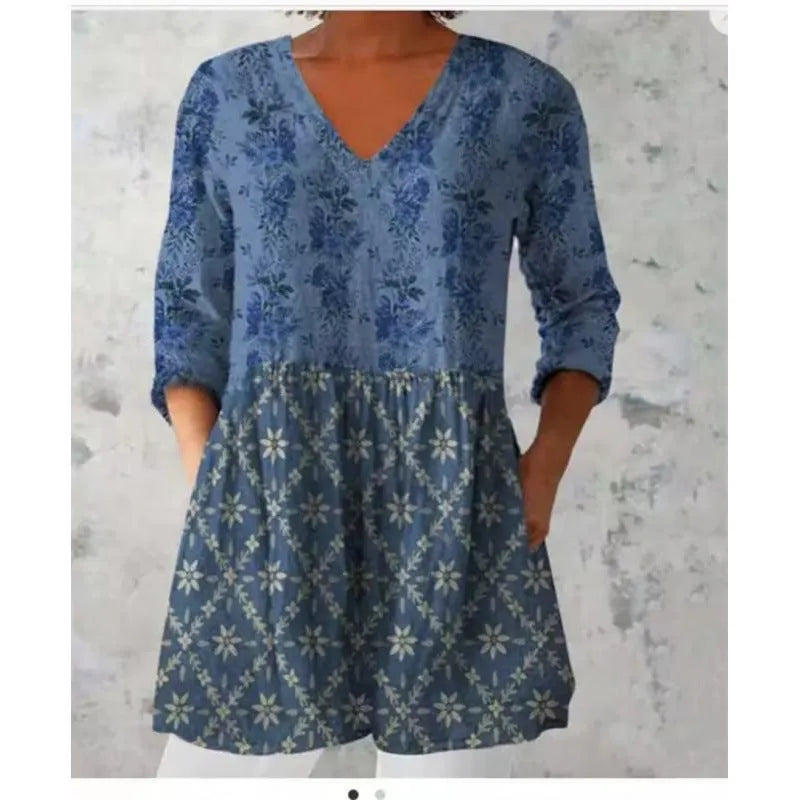 A woman wearing a loose-fitting dress with a blue and white wave print, featuring a wide waist and 3/4 length sleeves.