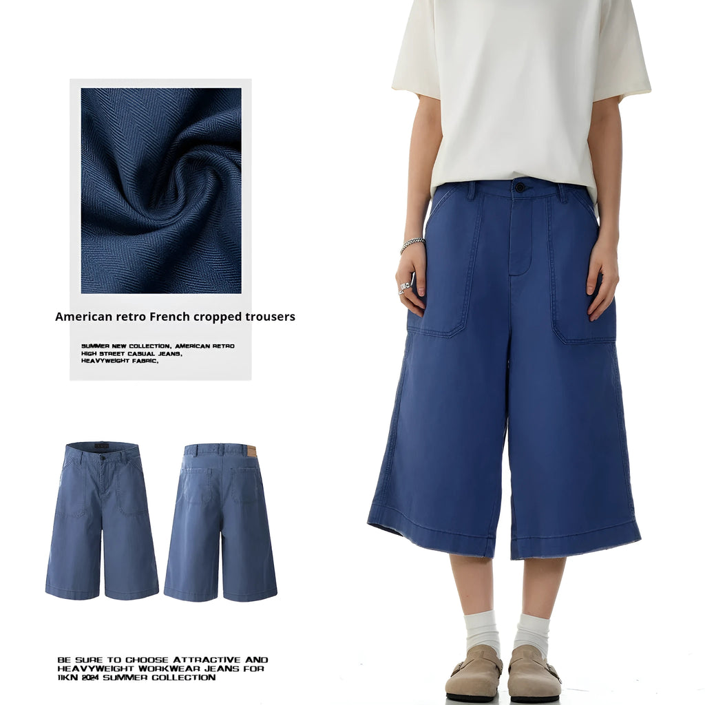 Men's French blue cotton shorts, loose straight-leg fit, mid-rise waist with zipper fly, lying flat.