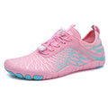 White and pink lace-up upstream sports shoes with a rubber sole on a neutral background.