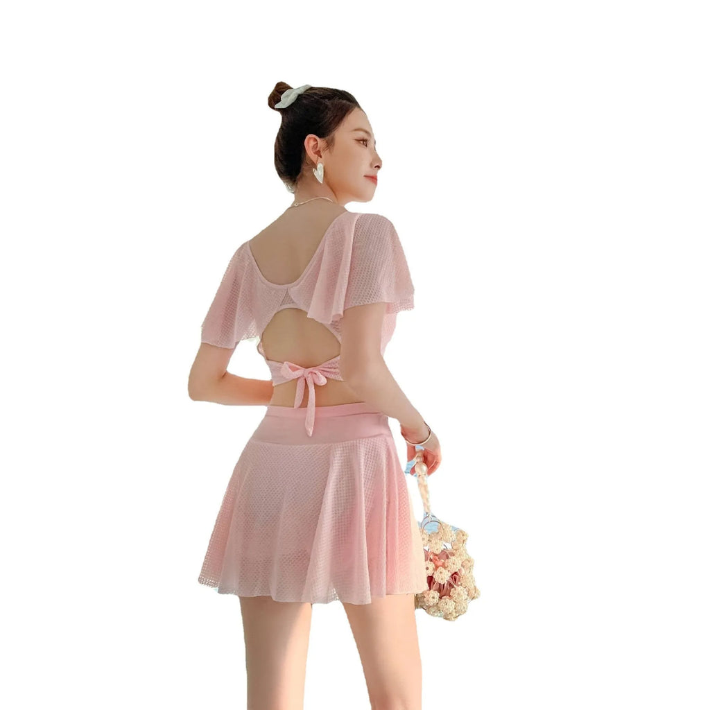 Women's solid colour two-piece swimsuit with a skirted bottom in white, black, or pink.