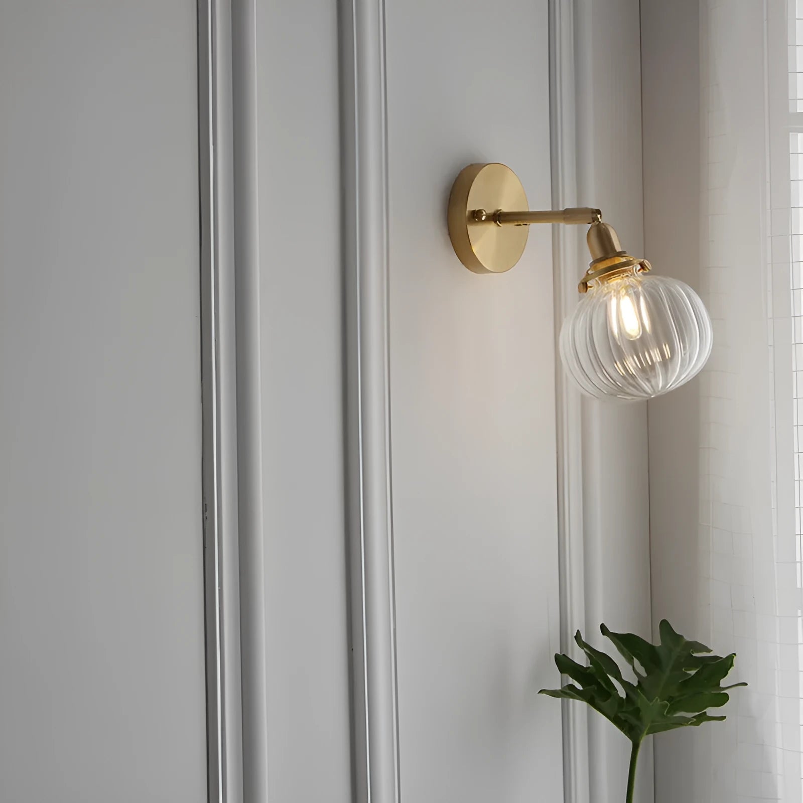 Pumpkin-shaped glass wall lamp in blue and transparent water ripple finishes mounted on a wall.