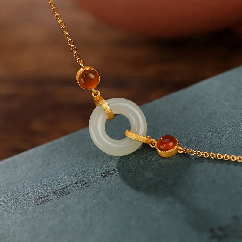 Gold plated S925 sterling silver bracelet with an inlaid natural Hetian jade peace buckle charm.