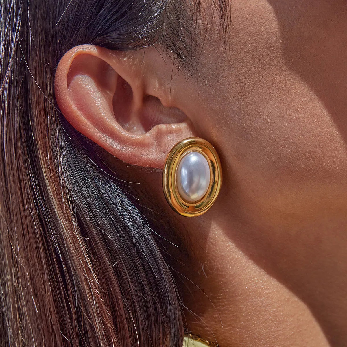 A pair of stainless steel stud earrings with a vintage pearl centre in a silver-tone finish.