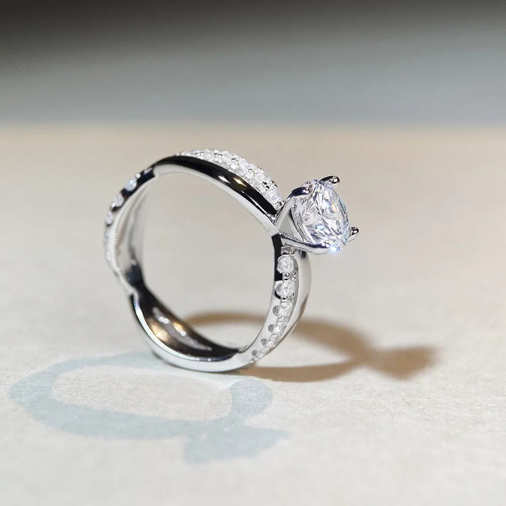Silver ring with twisted geometric band and a 1 karat moissanite in a four-claw setting.