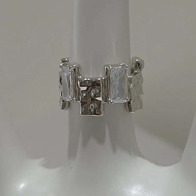 Silver plated open ring with cross design and zircon crystals.