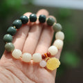 Woven bodhi bracelet with gradient white jade beads and natural beeswax lotus pendant on wrist
