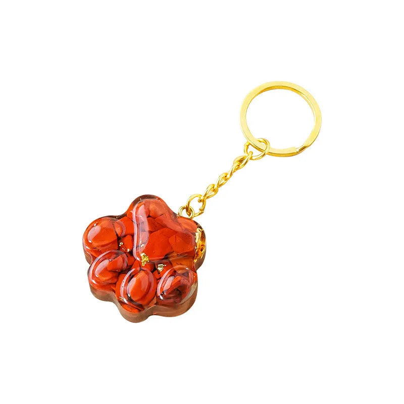 Natural crystal cat's paw keychain pendant on a stainless steel ring, showing detailed carving.