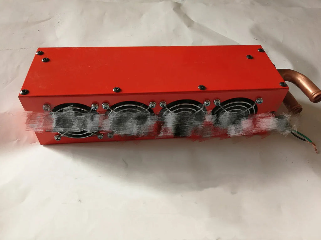 Long small metal car heater with four-hole copper pipe connections for 12V 24V systems.