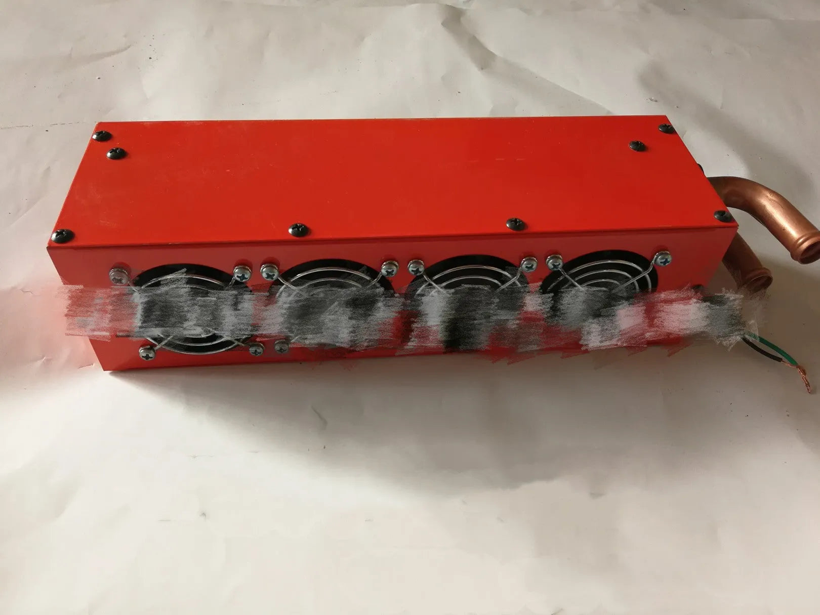 Long small metal car heater with four-hole copper pipe connections for 12V 24V systems.