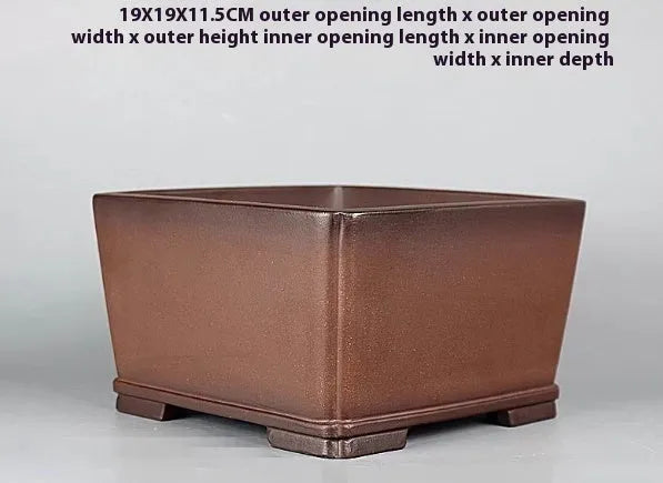 Handmade brown antique-style purple clay square flower pot on a surface.
