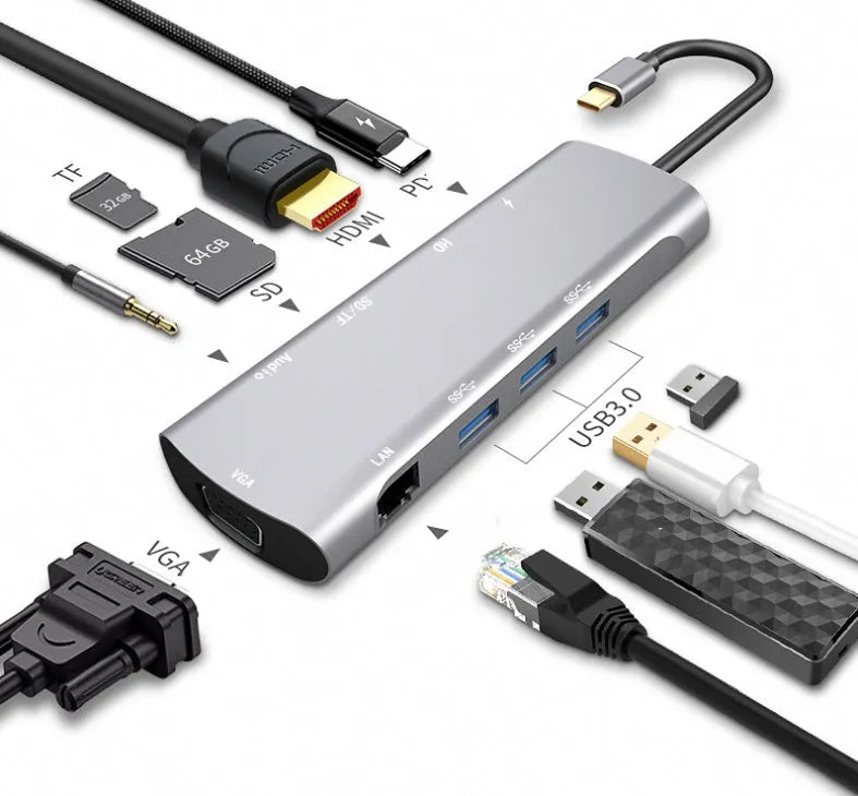 Grey aluminium USB-C docking station with HDMI, VGA, USB, and charging ports on a wooden desk.