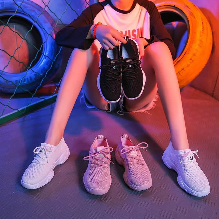 Women's white fly-knit sports shoes with thick rubber sole and front strap.