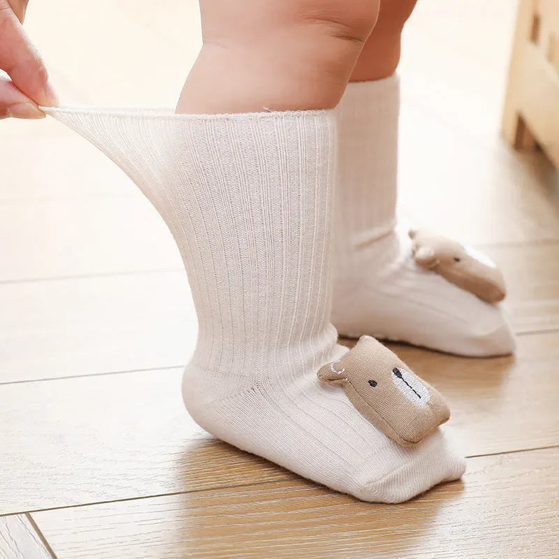Pair of light grey baby socks with white non-slip silicone grip dots on the soles.