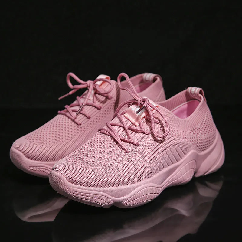 Women's white fly-knit sports shoes with thick rubber sole and front strap.