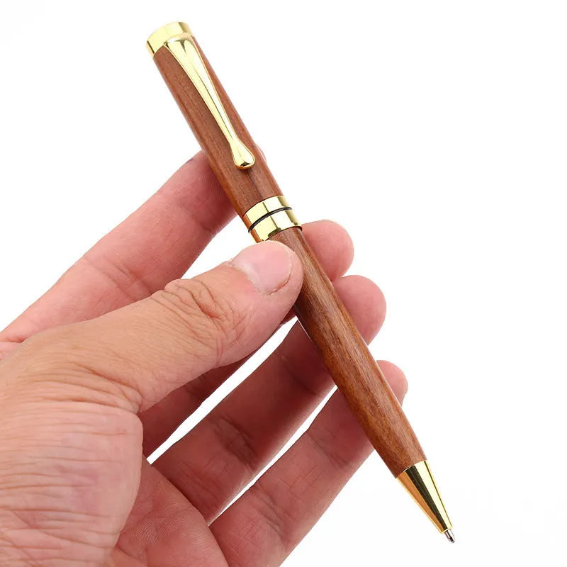 Gold metal and rosewood rollerball pen on a desk, 14cm long