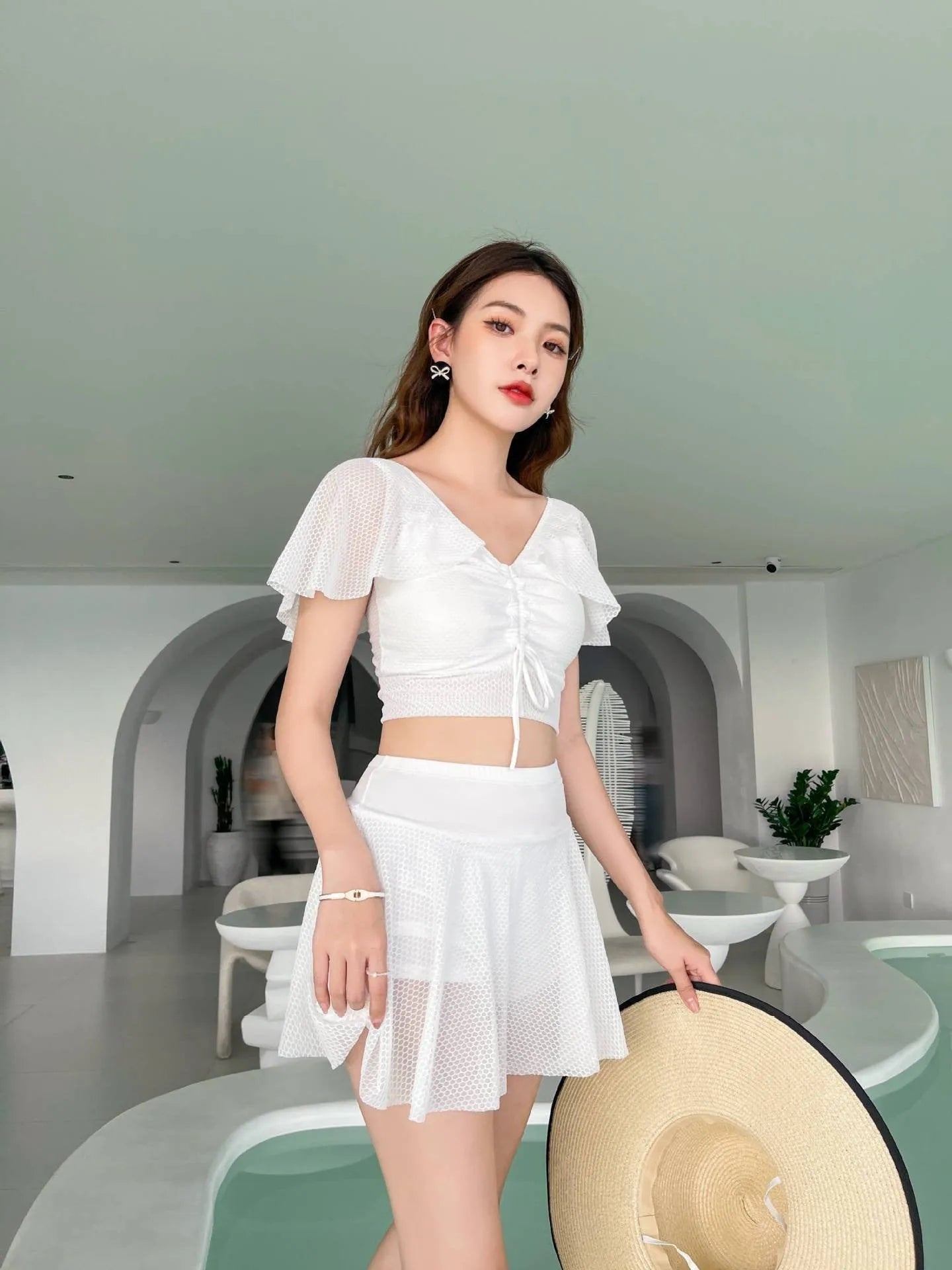 Women's solid colour two-piece swimsuit with a skirted bottom in white, black, or pink.