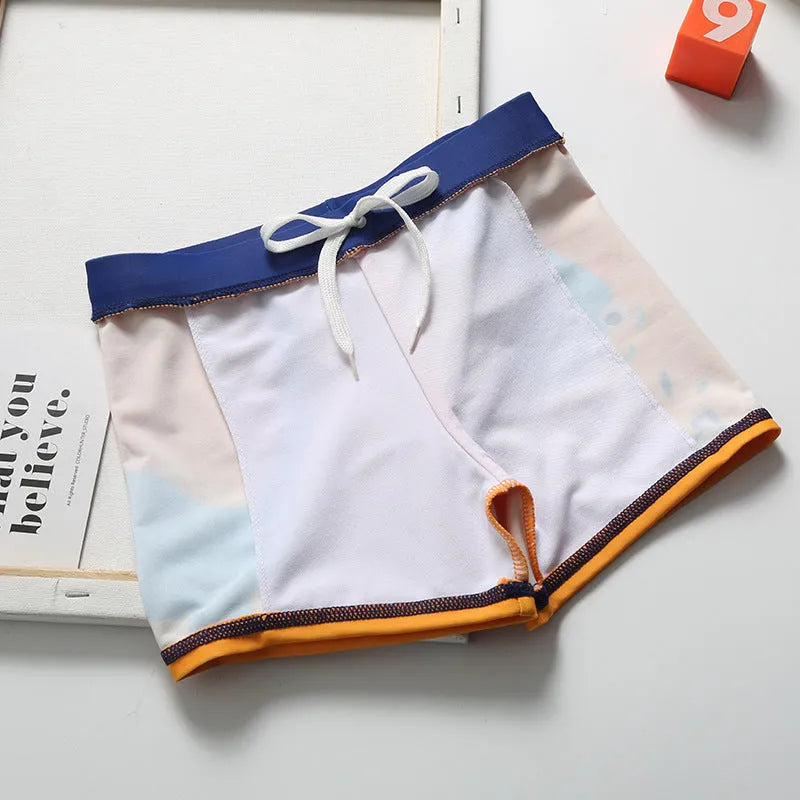 Cartoon dinosaur swimming trunks set for boys in light blue, dark blue, and orange colours