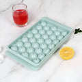 Blue 33-grid round silicone ice cube tray with transparent lid next to pink version, showing dimensions.