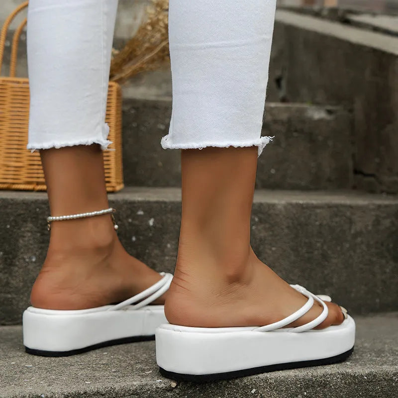 A pair of thick-soled flip-flops in a herringbone-patterned PU upper, shown in one of the available colours.