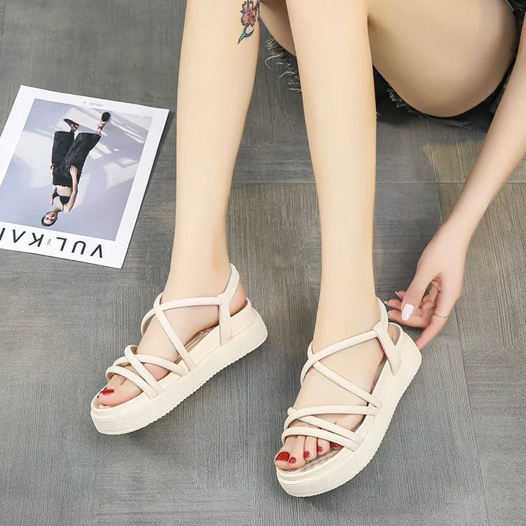 Women's black and beige Roman-style platform wedge sandals on a white background