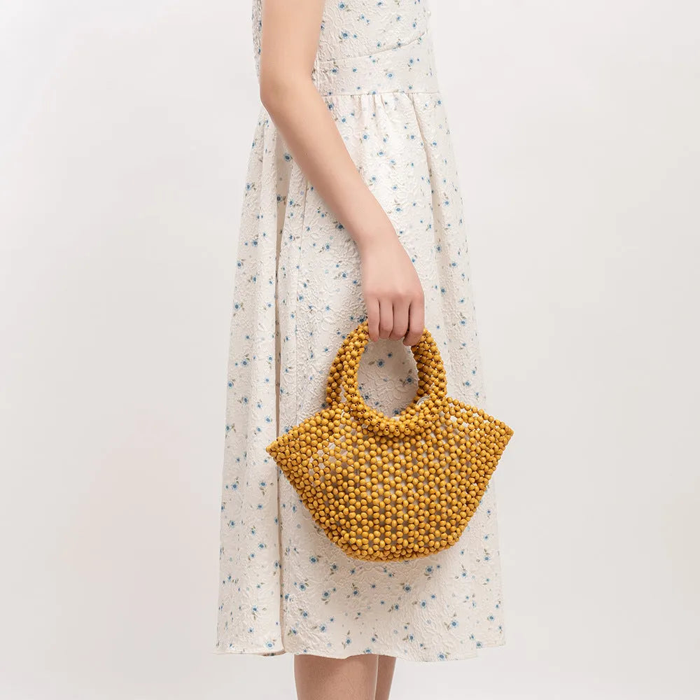 Hand-woven maple wood hollow handbag with wooden bead decoration in dumpling shape