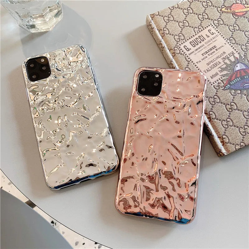Rose gold and silver coloured TPU back cover cases for iPhone on a plain background.