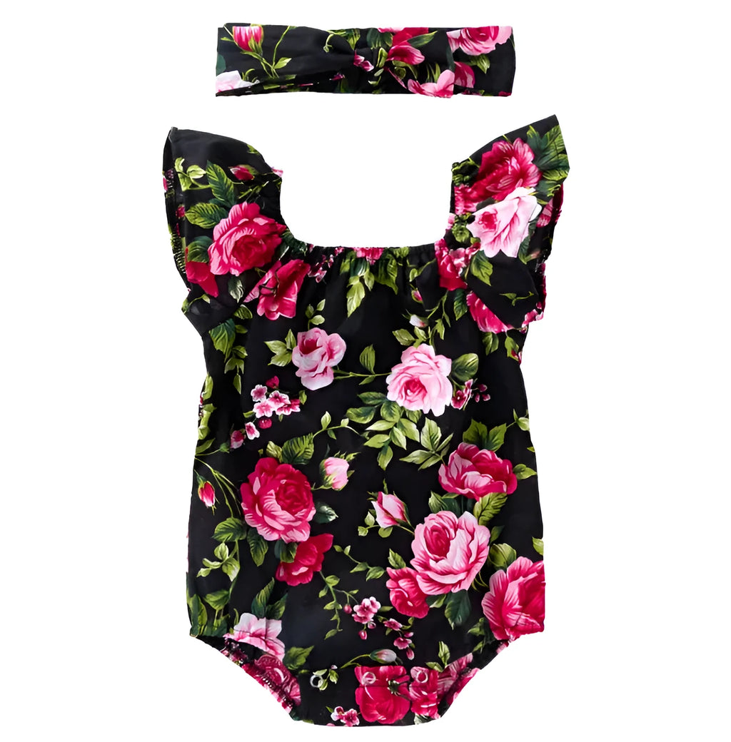 Baby girl in a black cotton romper with small flying sleeves print, showing sleeveless triangle climbing style.
