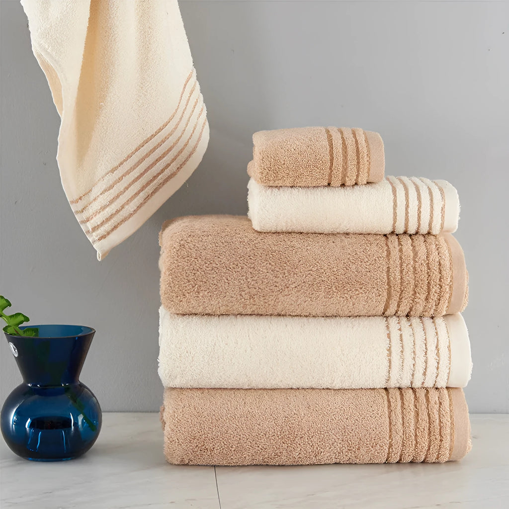 Set of three cotton towels in beige and brown including large bath towel, hand towel, and small washcloth
