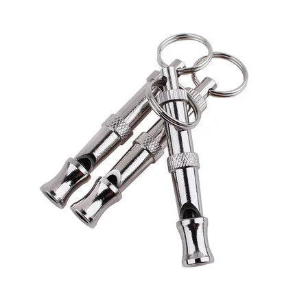 Silver ultrasonic adjustable dog training whistle made from stainless steel on a light background