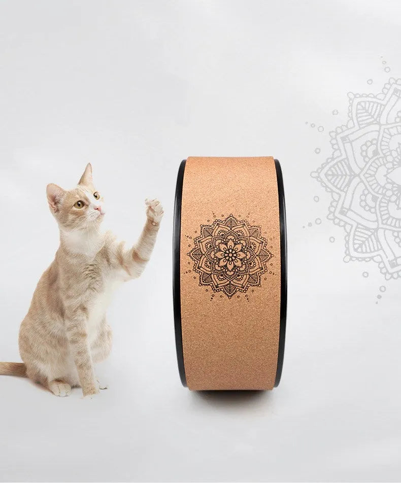 Brown cork yoga wheel with Mandala flower design on a wooden floor