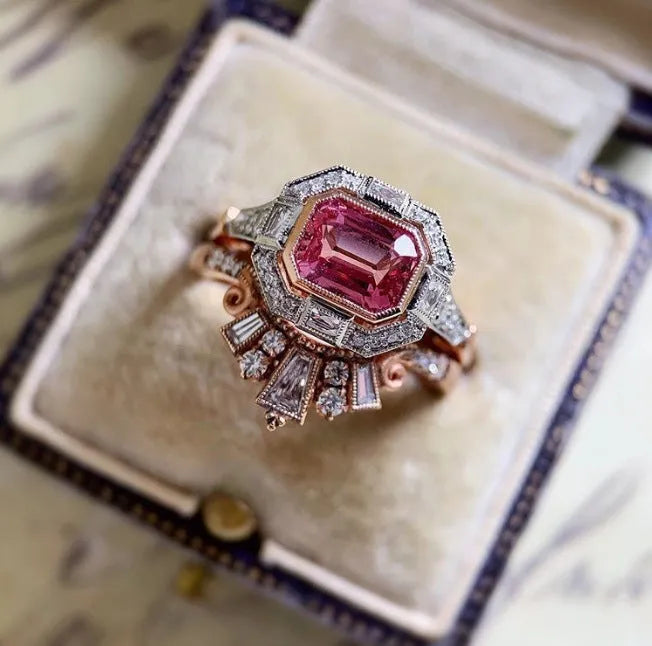 Women's retro-style geometric ruby ring in rose gold alloy on a hand.