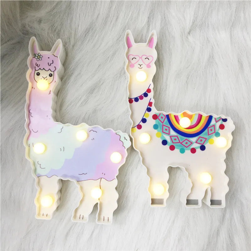 Alpaca night light in white, 19cm tall, with soft LED glow on a bedside table