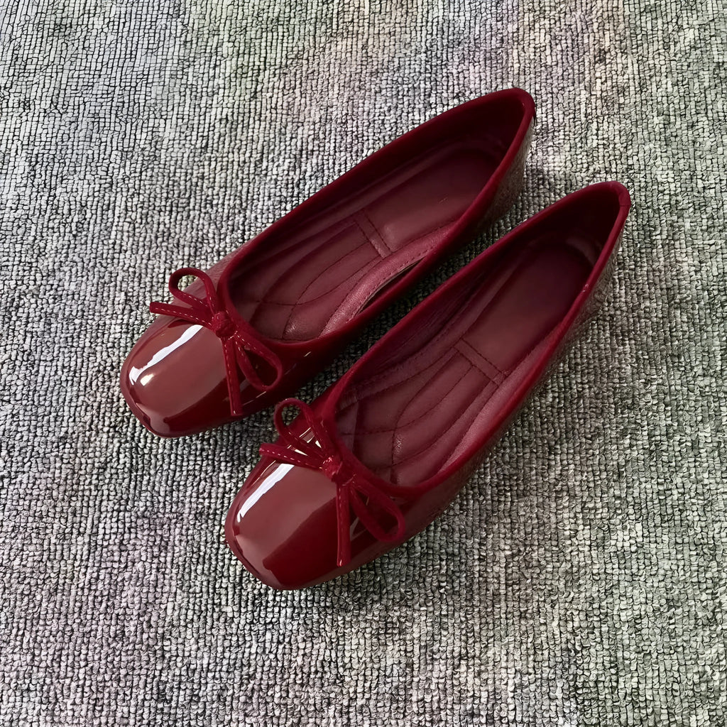 Pair of black patent leather Mary Jane flats with low heel and round toe