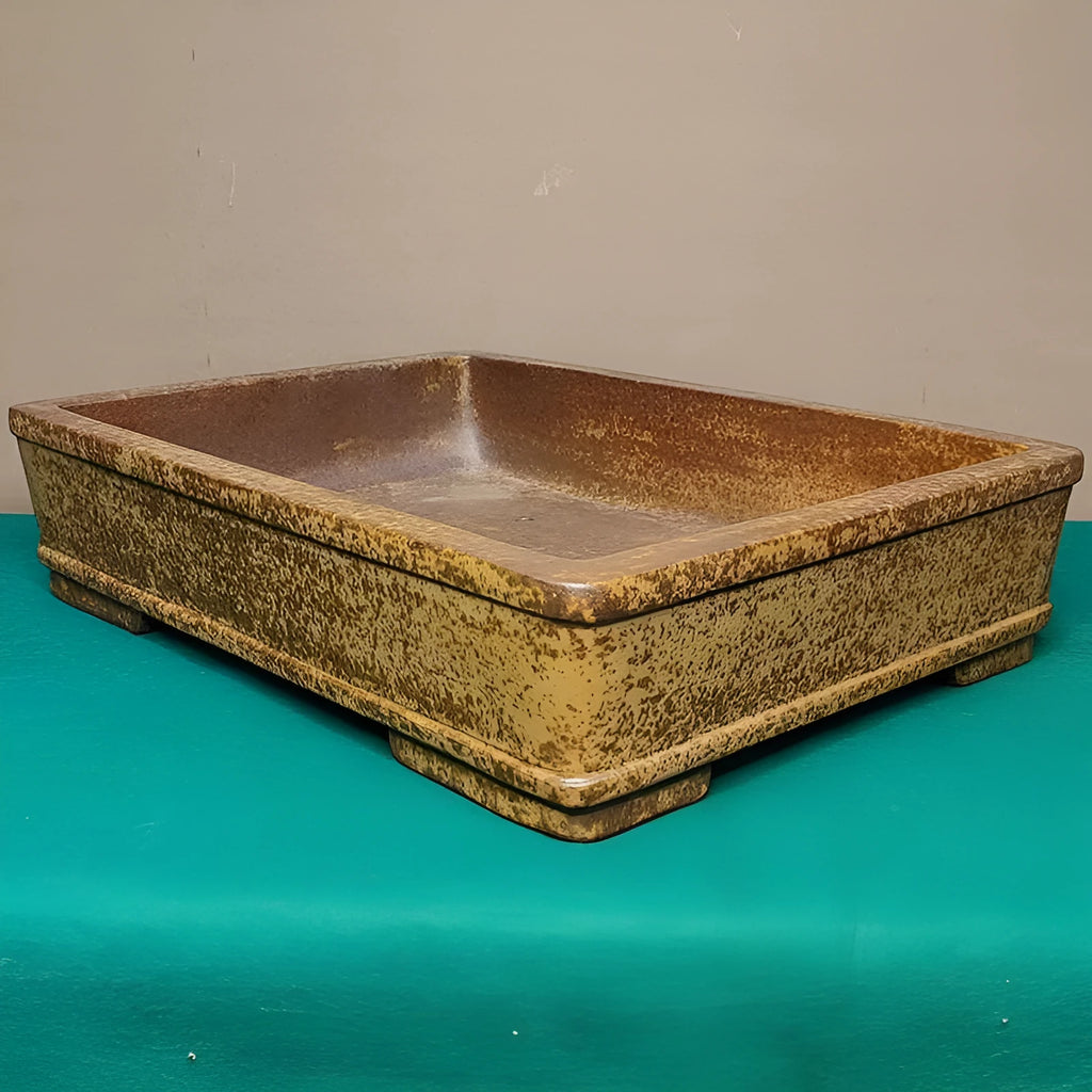 Straight-sided shallow rectangular Yixing flower pot in natural purple sand clay on a wooden surface.