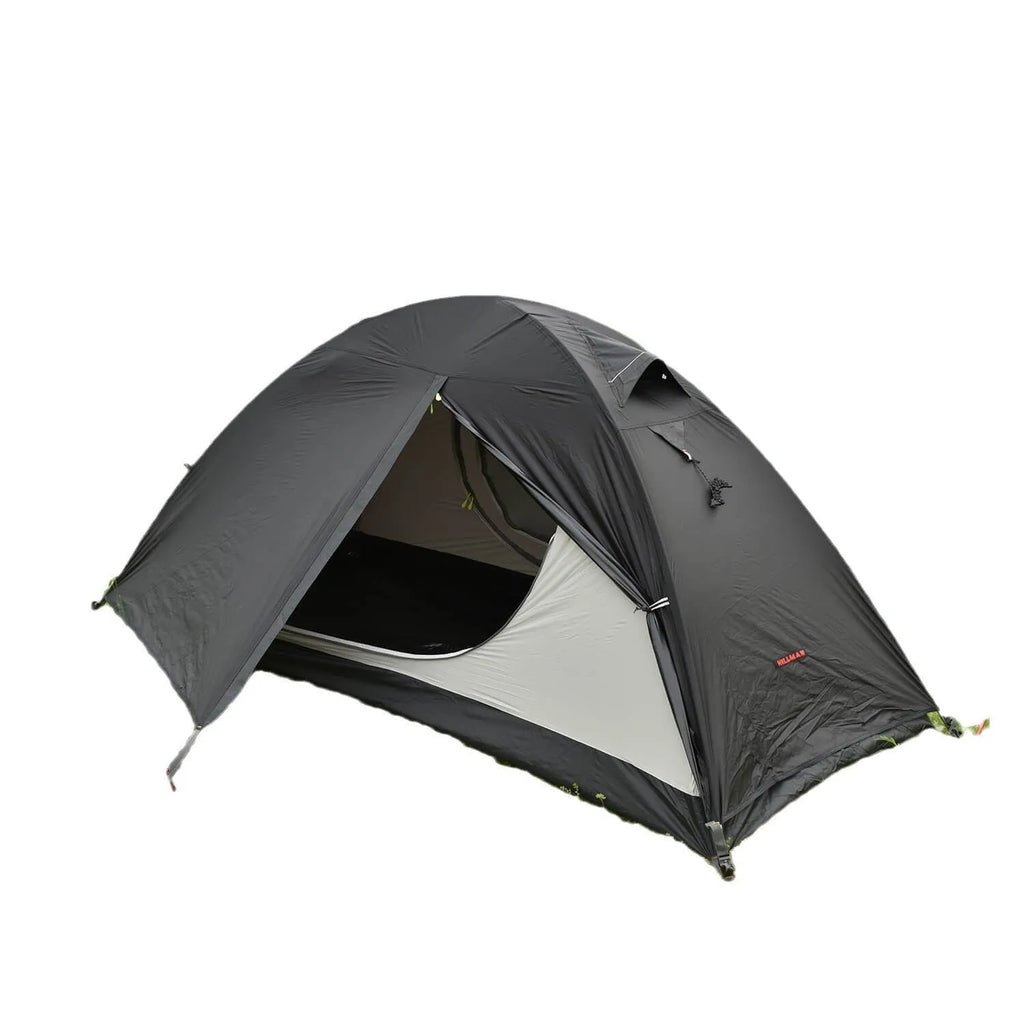 Red single-person backpacking tent with aluminium poles pitched in a forest, showing double-skin design and mesh panel.