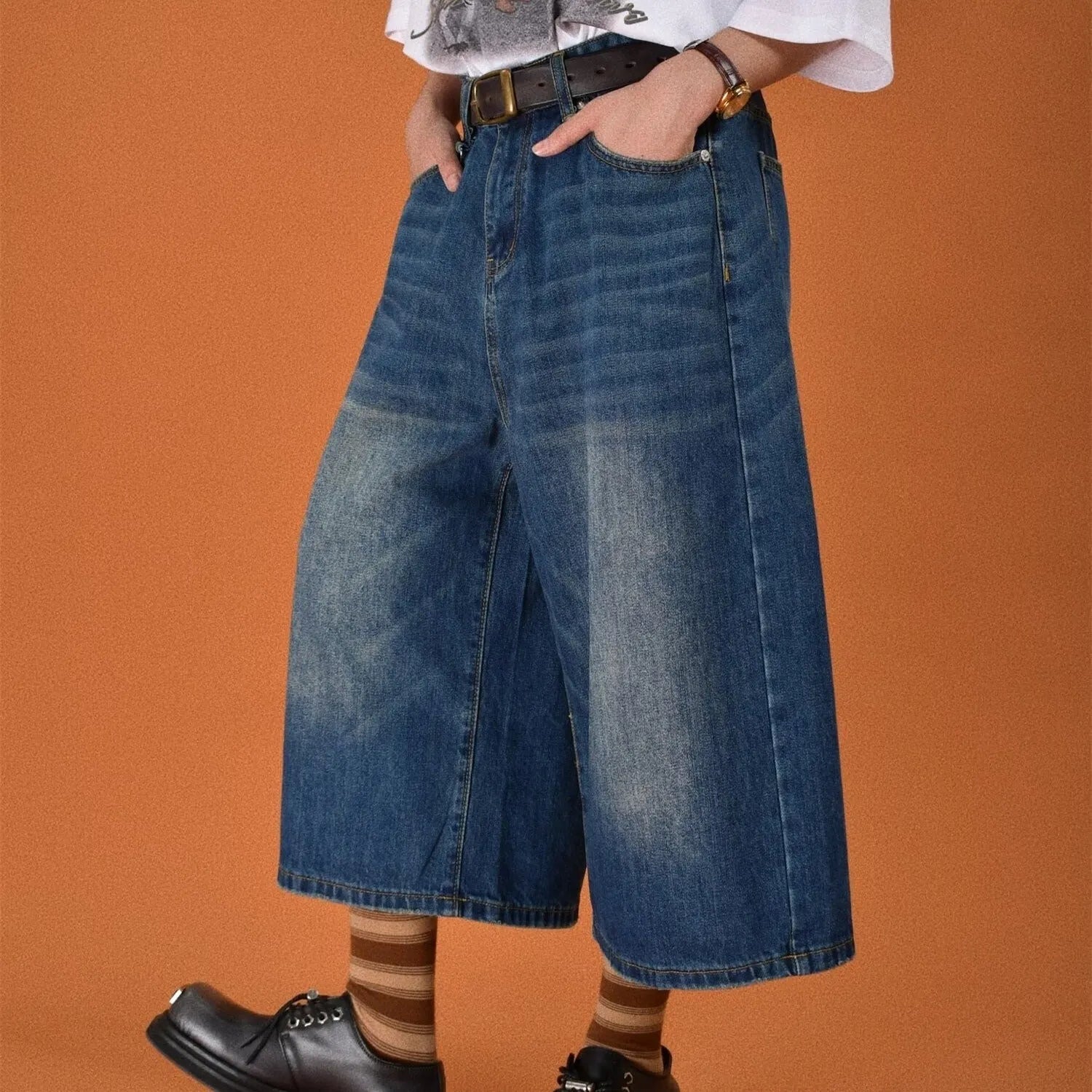 Men's loose-fit straight-leg denim shorts in a light blue wash on a hanger.