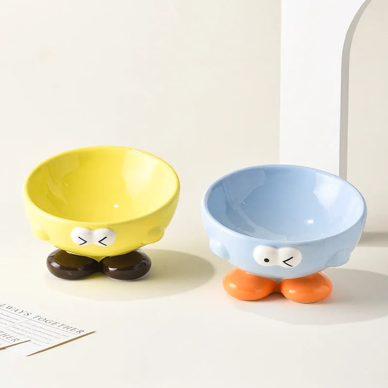 Ceramic slanted pet bowl with cute expression design in blue, yellow, and set colours for cervical spine support.