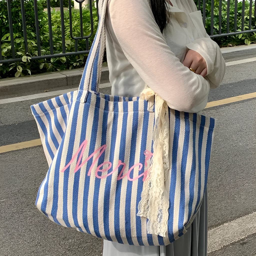 Blue striped letters printed on a pink, blue, and white striped cotton canvas bag for daily matching.