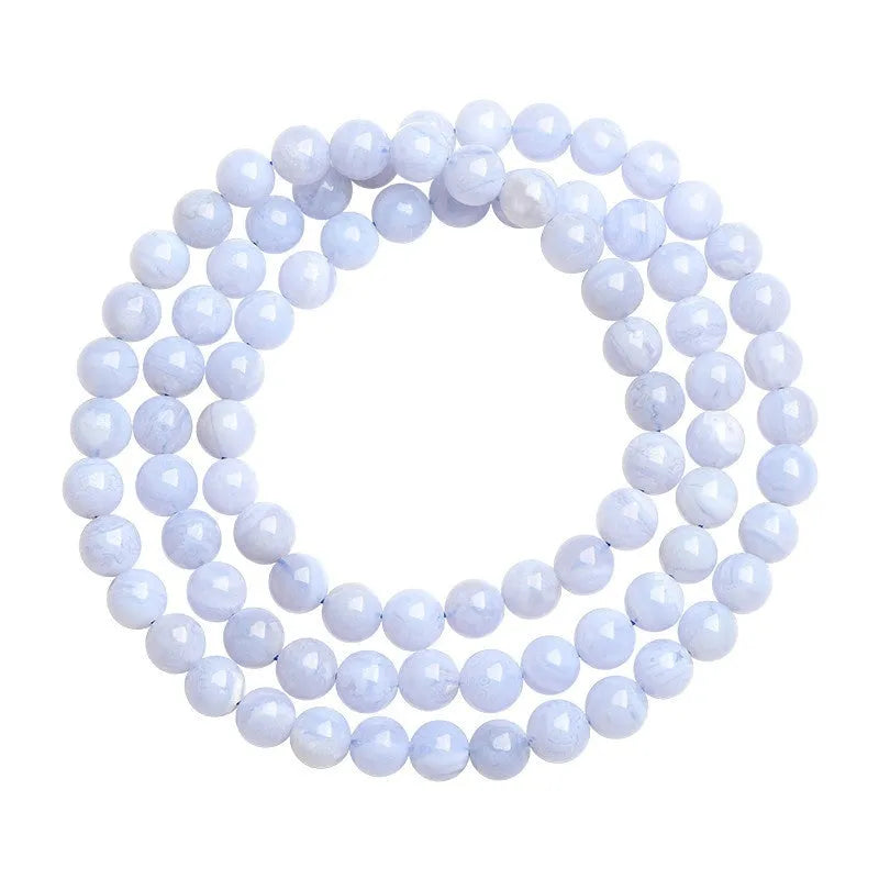 Close-up of a blue striped agate beaded bracelet with Ruyi design on a neutral background.
