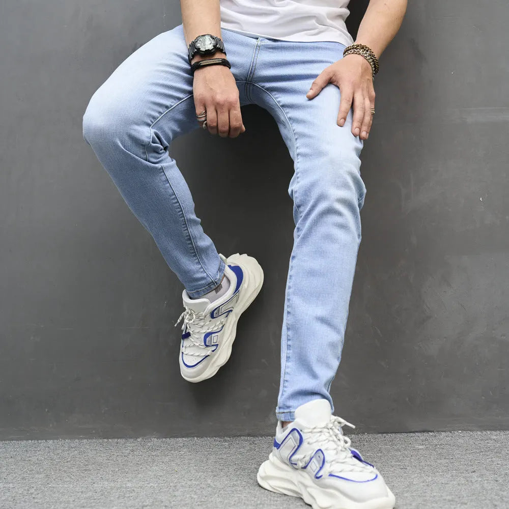 Light blue skinny cotton stretch men's jeans with mid waist and tapered leg on model