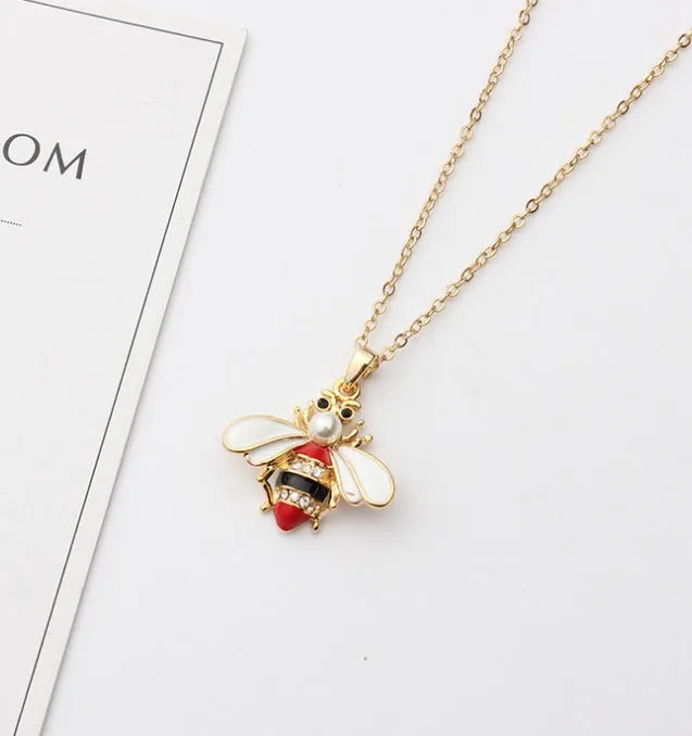Cartoon bee drop pendant necklace with oil studded alloy finish on cross chain, yellow colour option, on white background