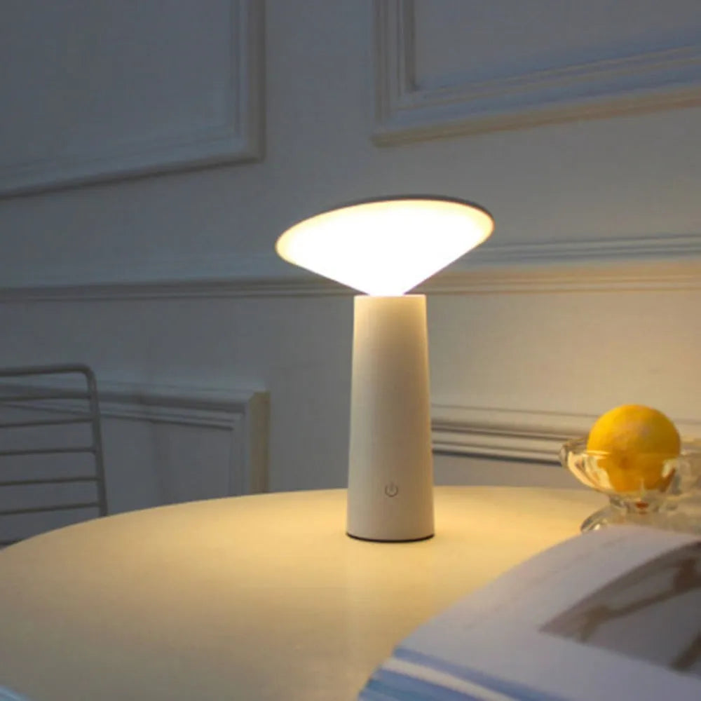 Black USB rechargeable LED desk lamp with touch sensor and adjustable lamp head on a wooden desk.