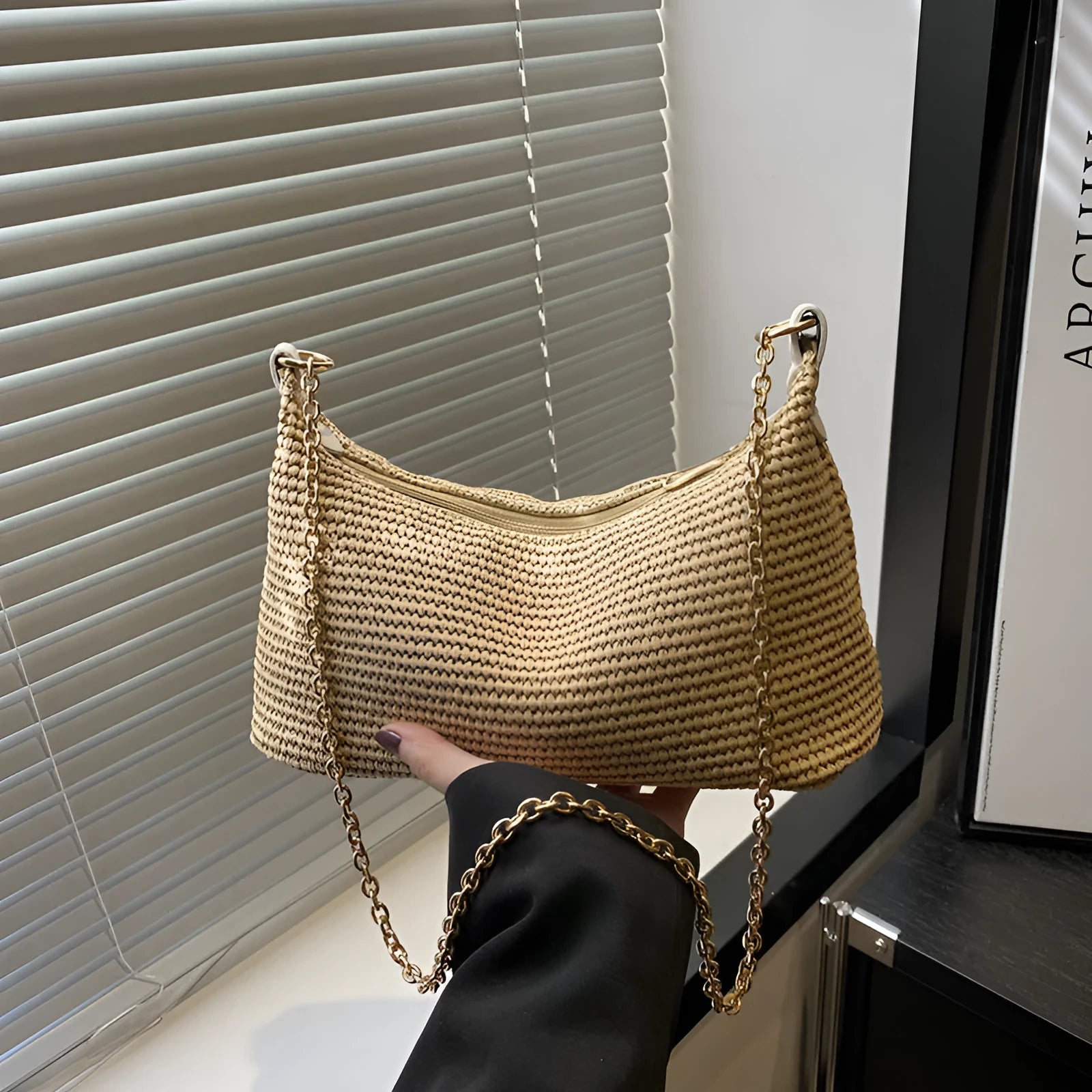 Woven straw beach shoulder tote bag in khaki colour with visible stitching and an outer pocket.