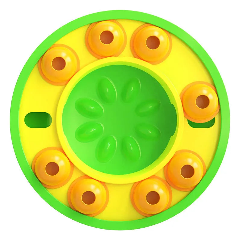 Square green dog puzzle toy with a central feeding well and a rotating turntable lid on a hard floor.