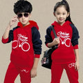 Children's black tracksuit set with printed design, showing jacket and trousers laid flat