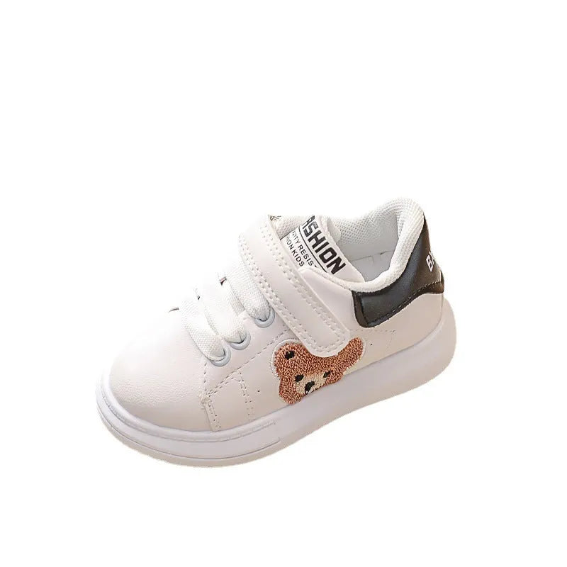 Children's black sports shoes with a cartoon bear design on the artificial leather upper and a rubber sole.