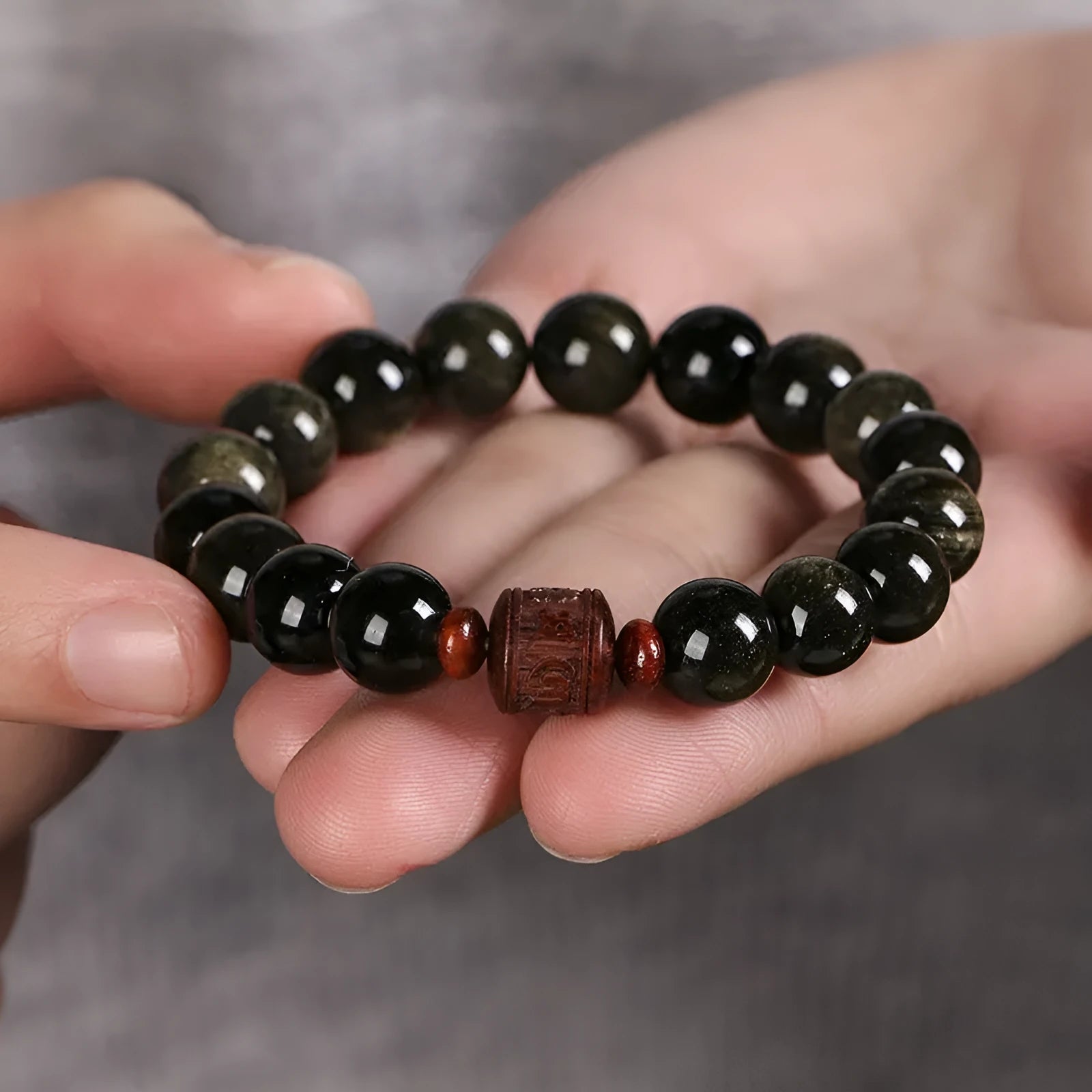 Close-up of a hand-woven Better Luck Beads bracelet with 10mm round Golden Obsidian beads in a retro style.