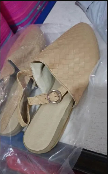 A pair of pointed toe, baotou flat sandals with a central buckle fastening, shown in a selection of colours.
